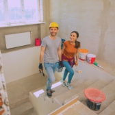 Imagem de um casal felizes construindo uma casa